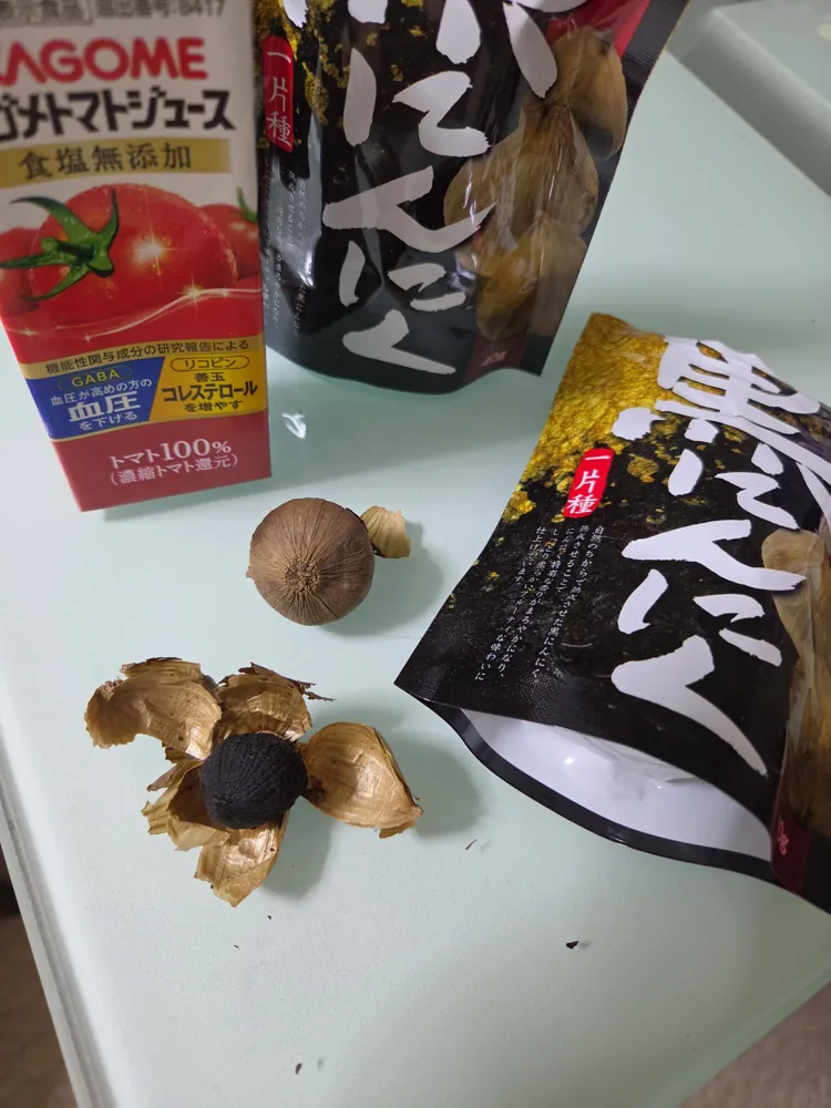 皮を剥いた黒にんにく。中身は真っ黒でねっとりした見た目。奥には一片種のパッケージ