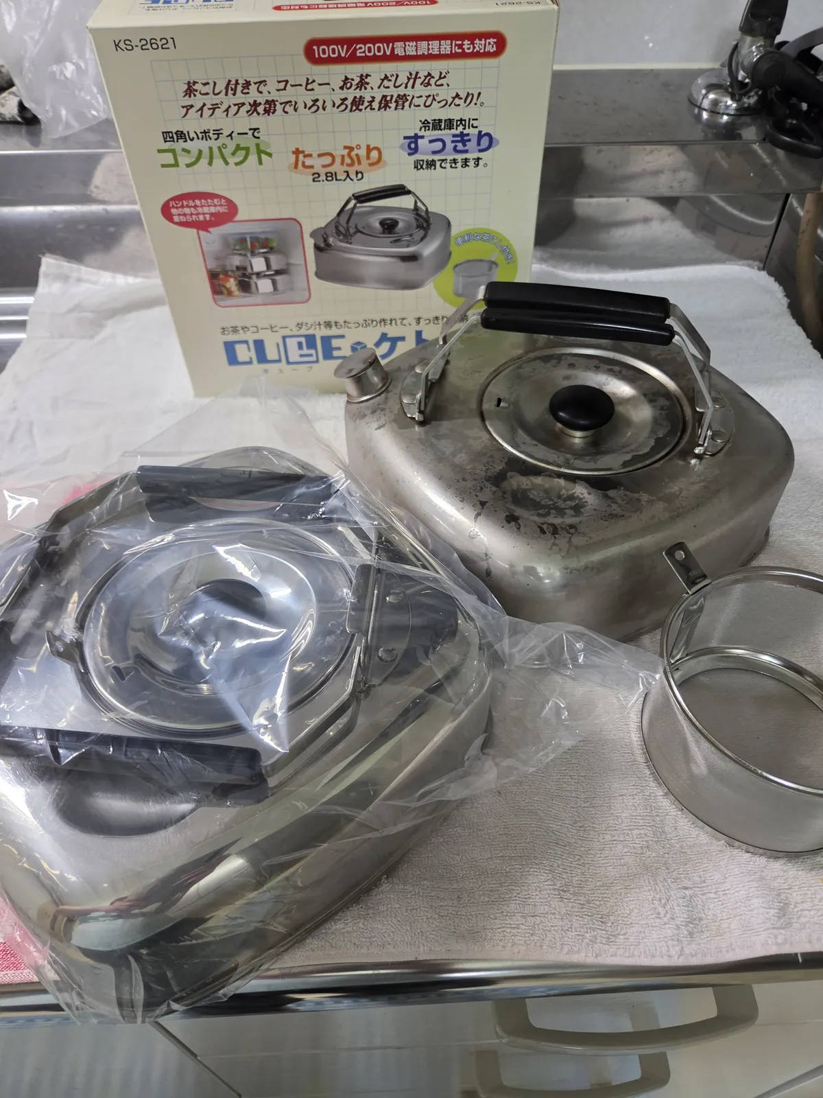 新しく買い足したキューブケトル（手前・袋入り）と、3か月使い込んだ1台目（奥）。後ろには2.8L入りの外箱
