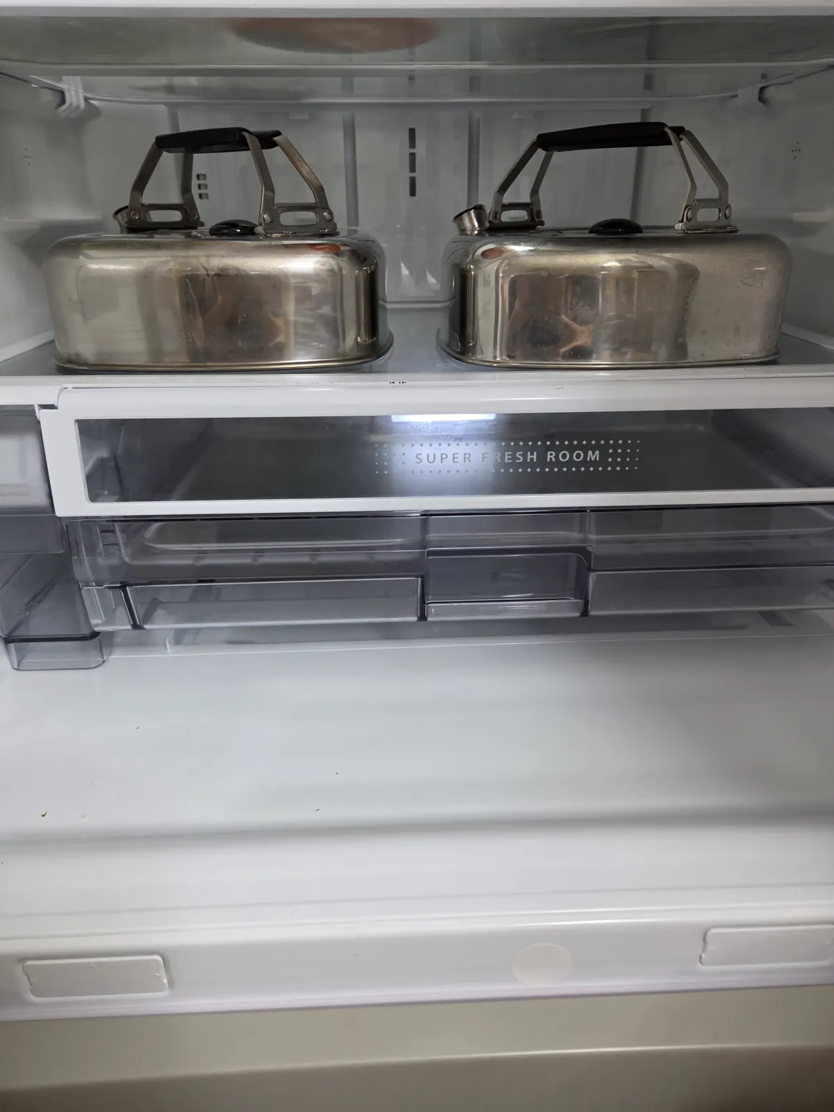 冷蔵庫の棚に2台並んだキューブケトル。左右どちらも持ち手を立てたまま収まっている