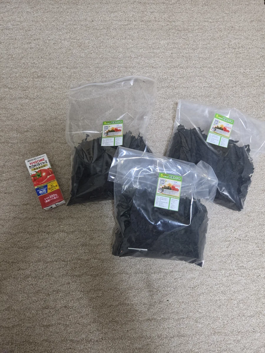 ネットでまとめ買いした肉厚乾燥わかめの袋（5袋中3袋が残っている状態）、大きさ比較のトマトジュース付き