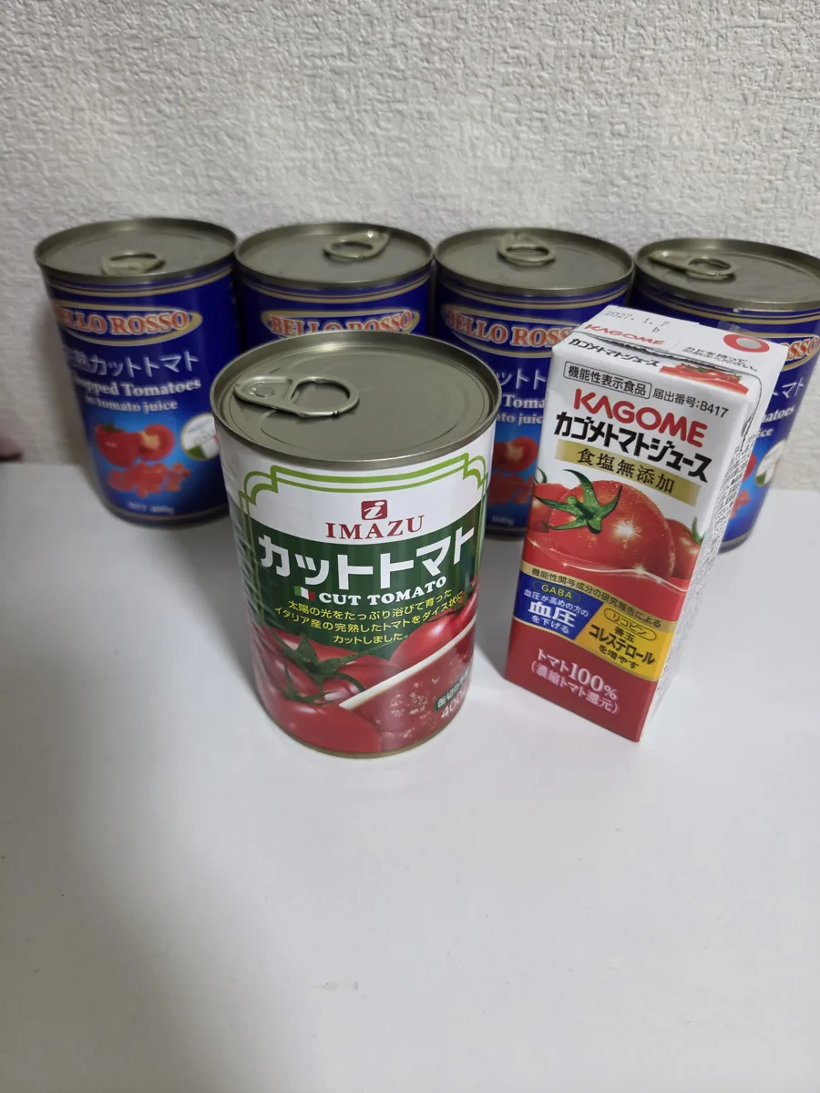 ストックしているカットトマト缶、大きさ比較のトマトジュース付き