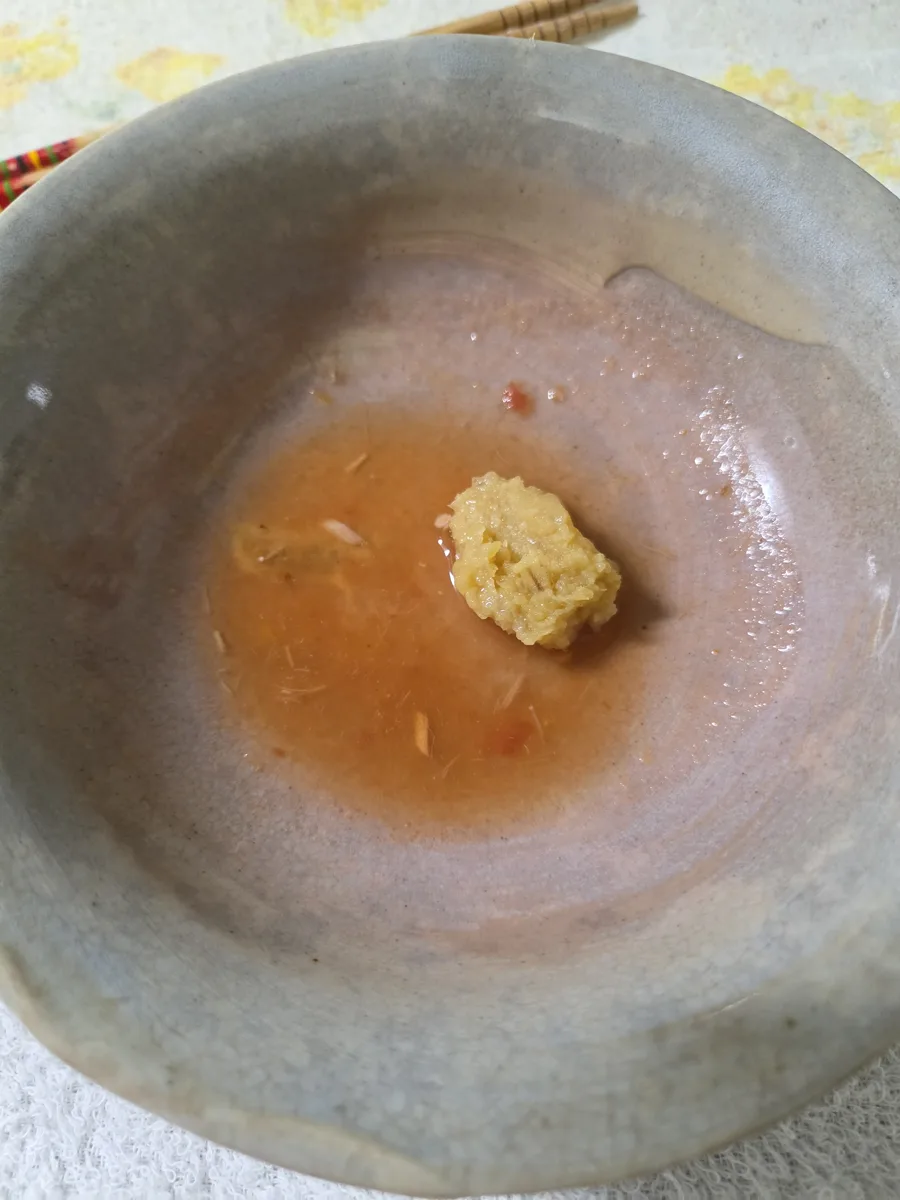 器に味噌を仕込み、少量のスープで溶いている様子
